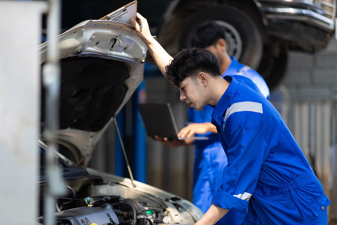 車のフロントを確認している整備士